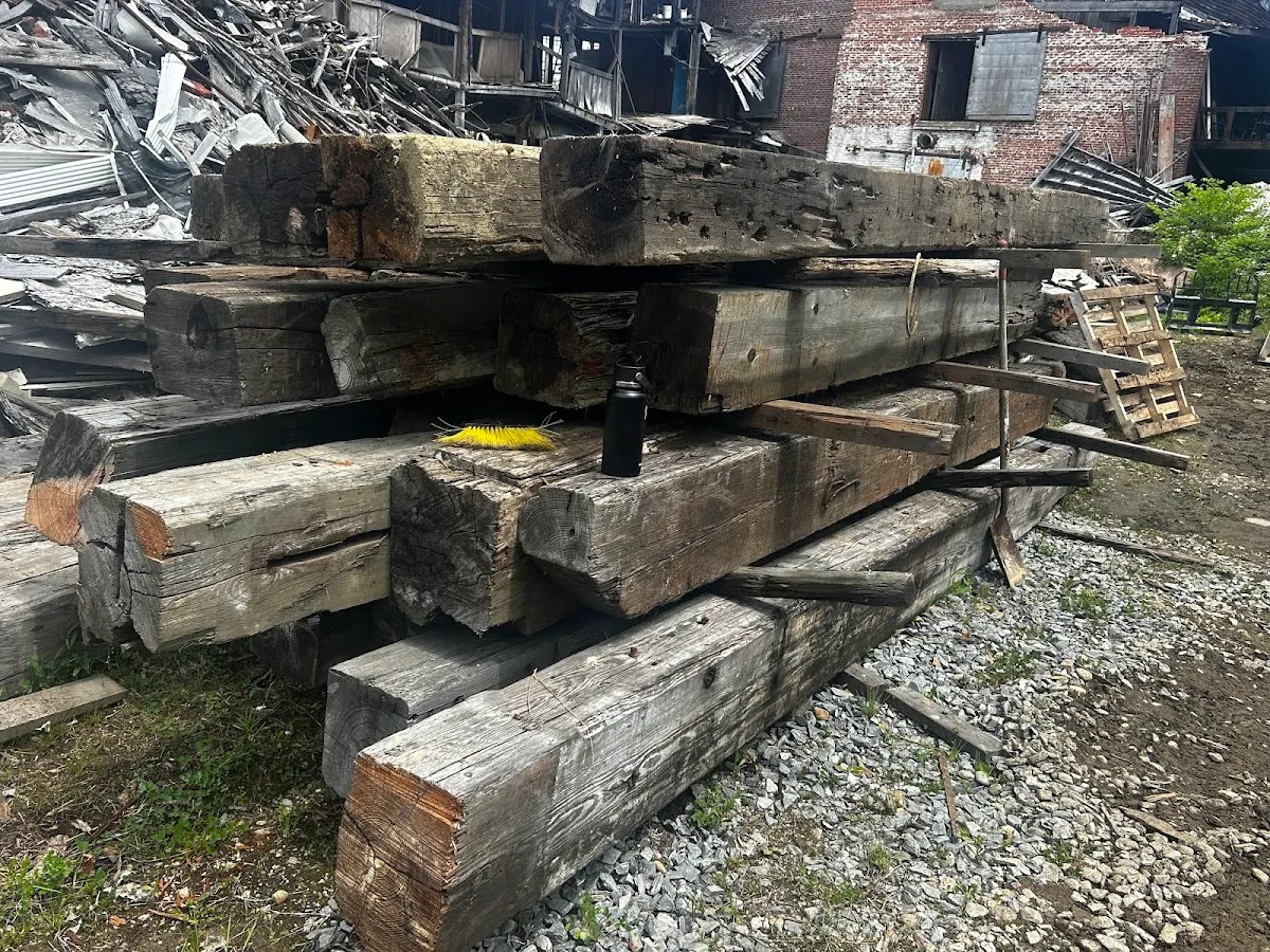 Large reclaimed beams arranged in stacks outdoors