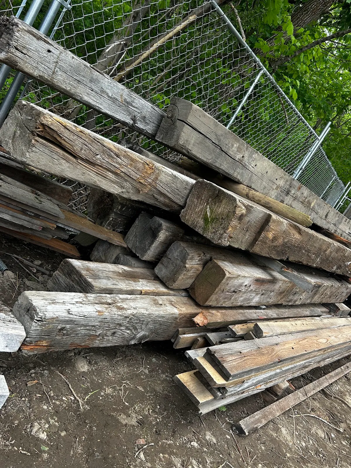 Weathered reclaimed beams viewed at an angle in the yard