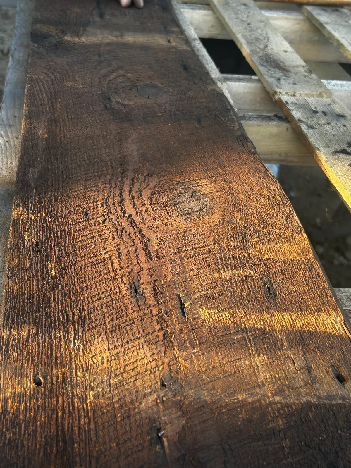 Dark reclaimed brown board showing its worn surface and grain