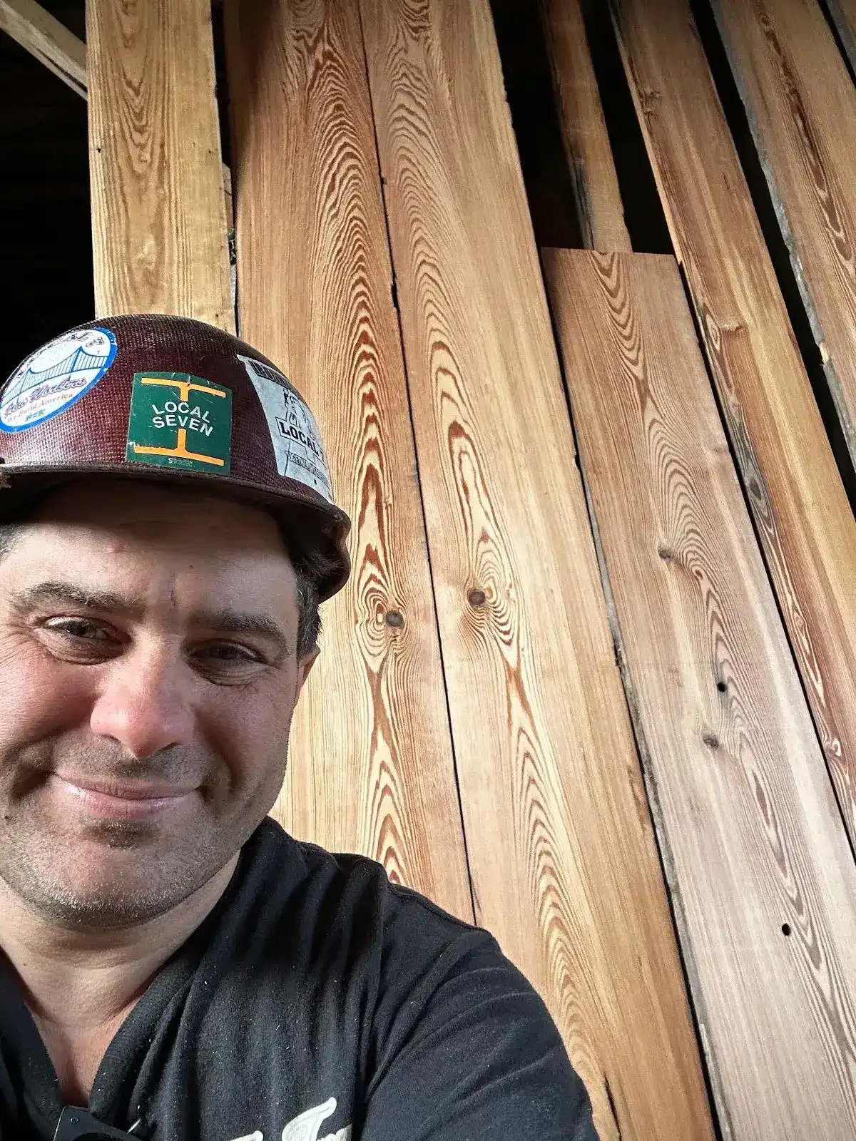Self-portrait beside vertical grain heart pine boards with strong repeating grain