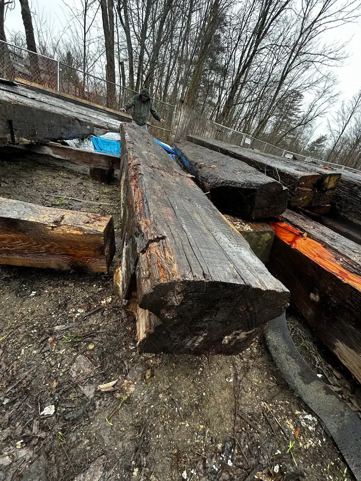 Dark reclaimed heart pine beam resting on timbers outdoors