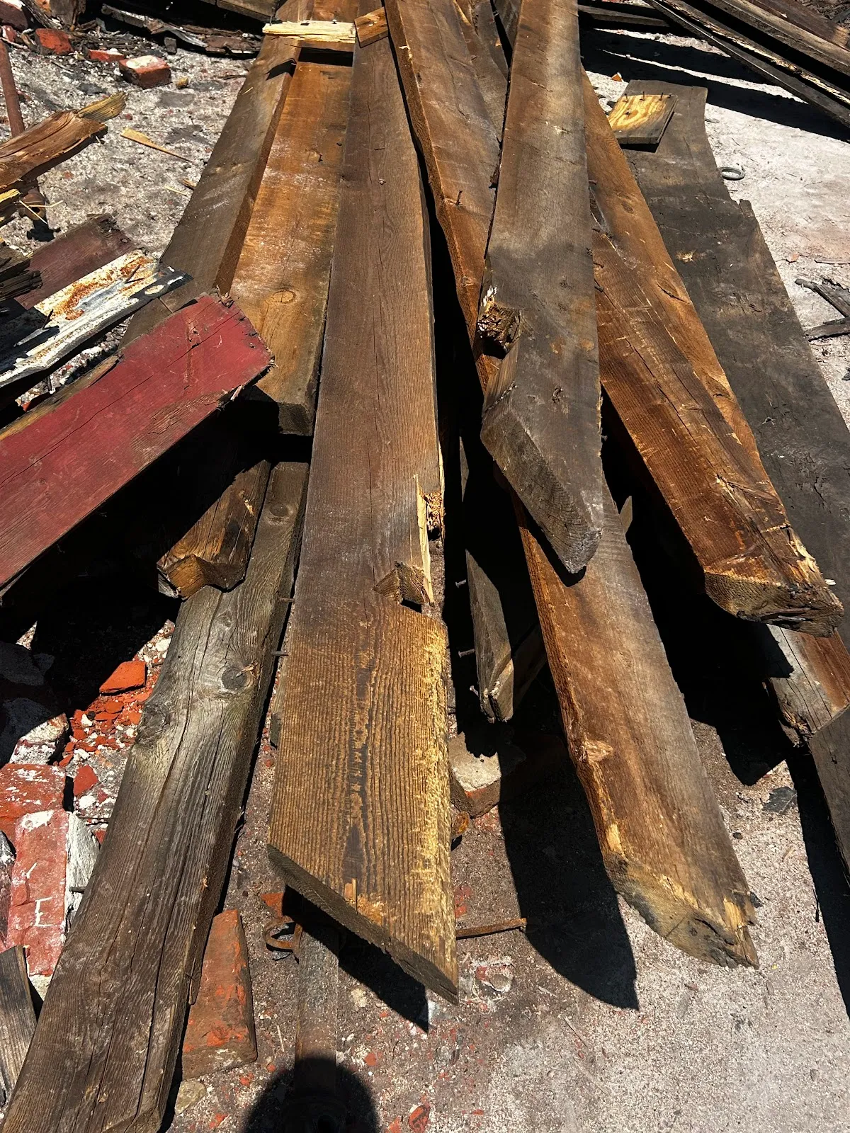 Long reclaimed boards and rafters arranged in a salvage stack