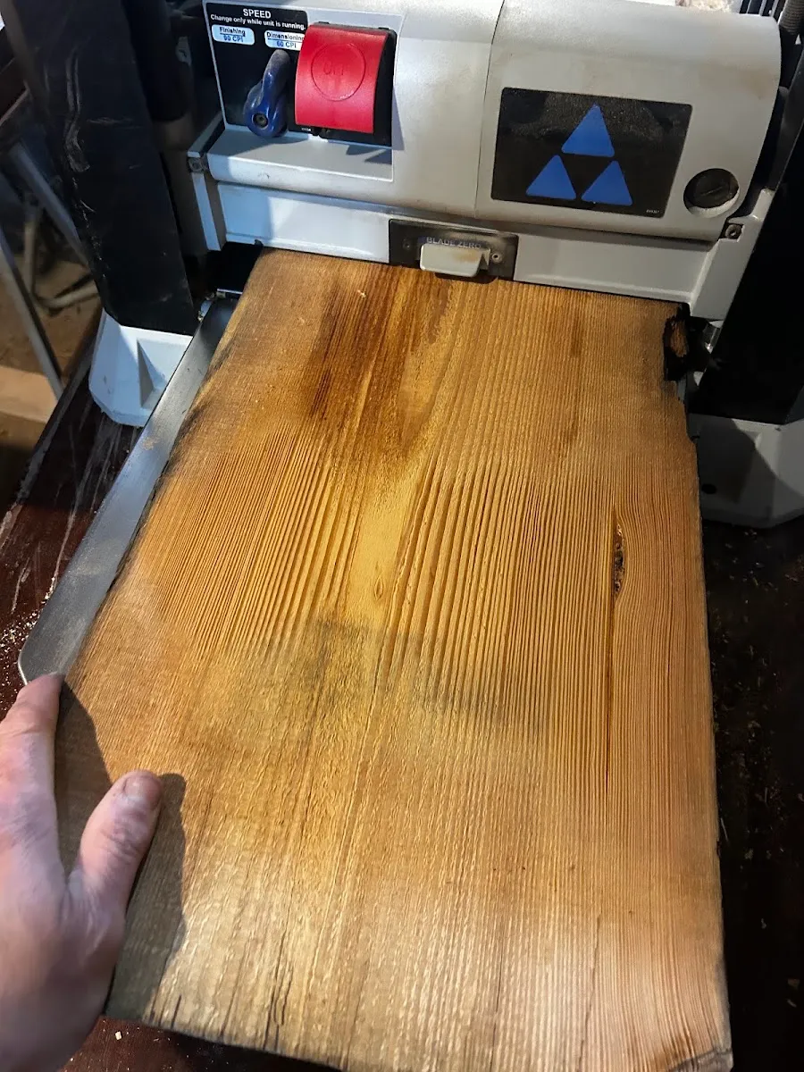 Reclaimed heart pine board being surfaced in the shop
