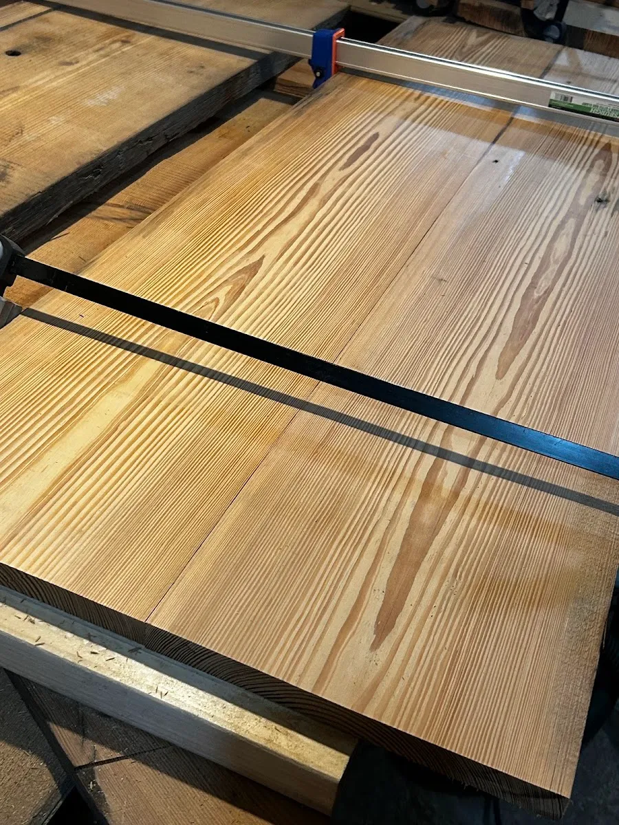 Heart pine top held with a straightedge and clamps while the grain is checked