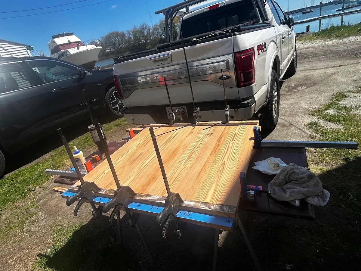 Reclaimed heart pine tabletop held in clamps during assembly