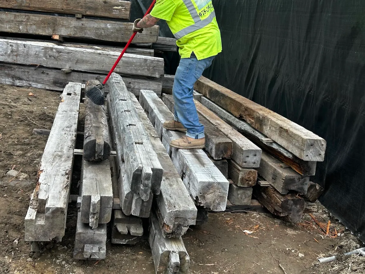 Reclaimed beams sorted into rows outdoors