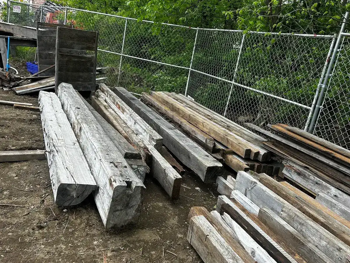 Reclaimed boards and beams stacked near milling equipment