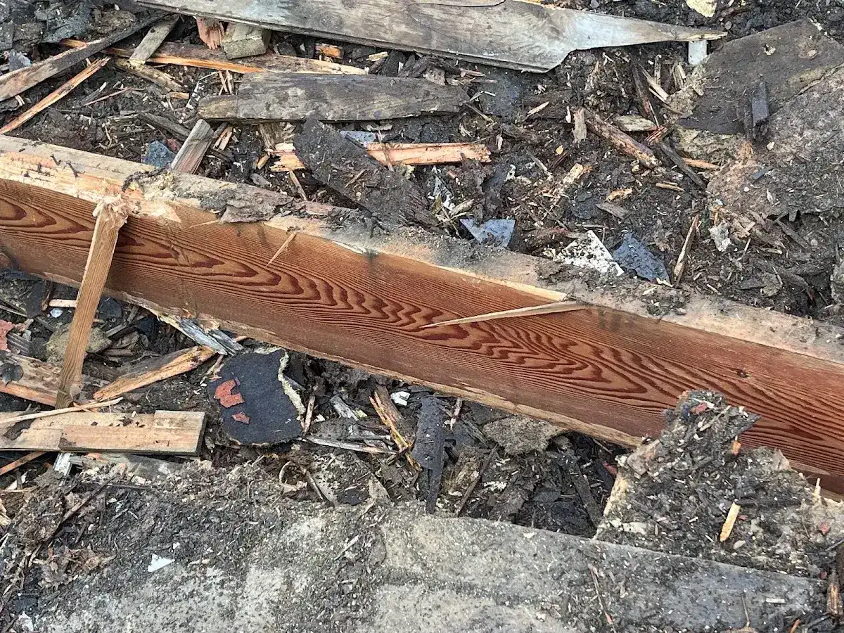 Weathered beam end being measured with a yellow tape measure